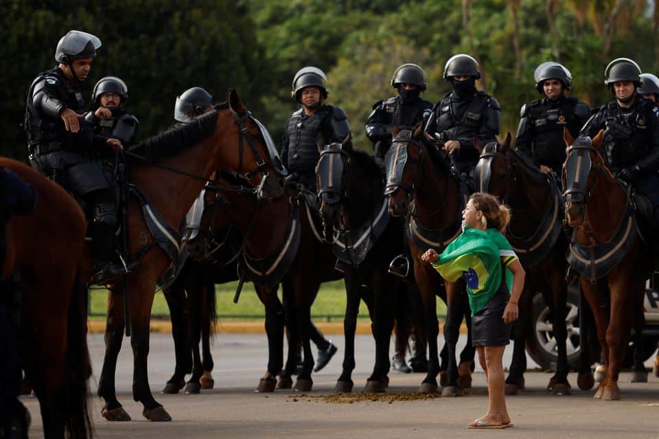 Manisfestante arodeada por policias en caballos