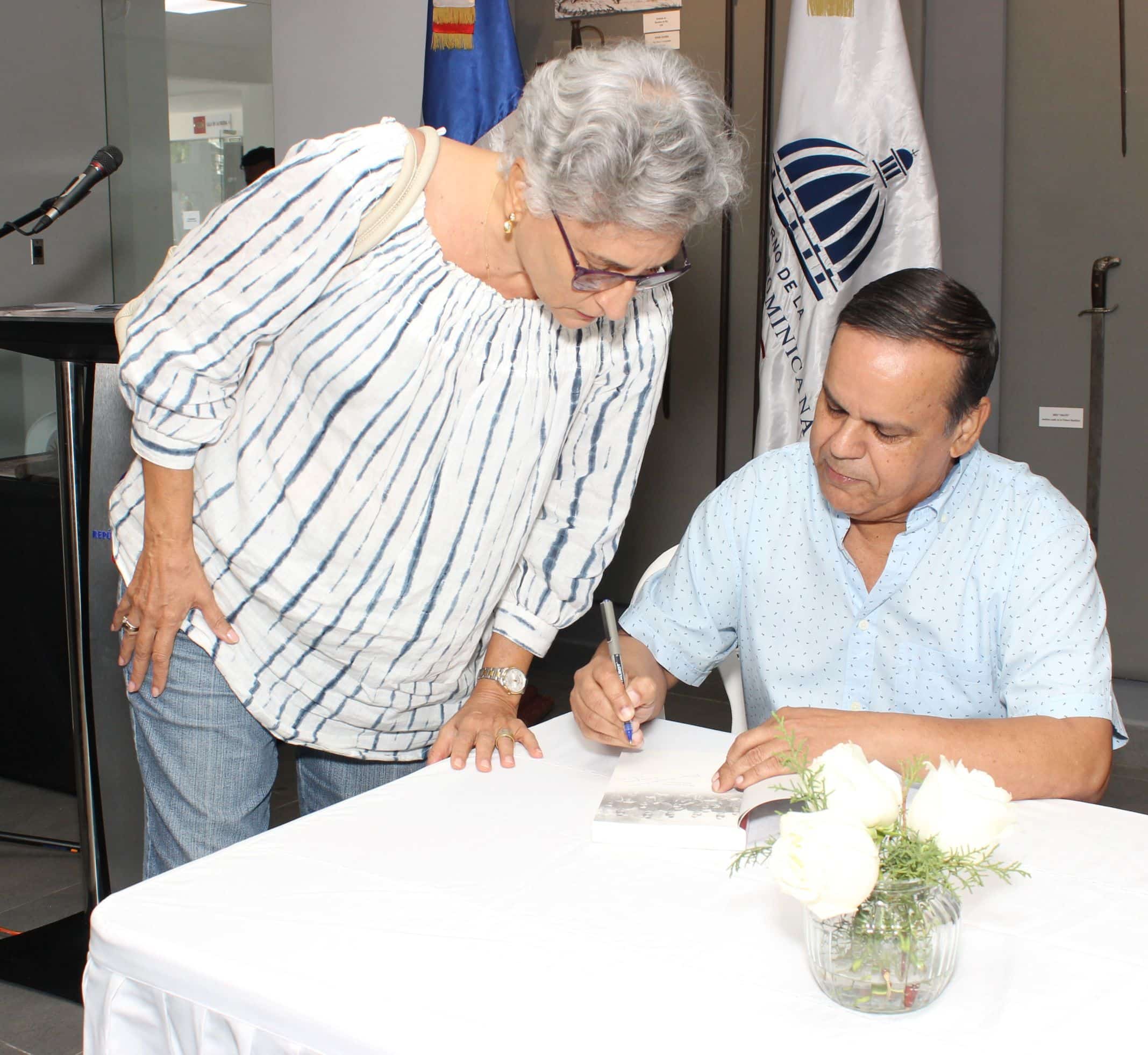 Orlando Inoa firma un ejemplar del manual "Breve historia dominicano" a Merche Siragusa.
